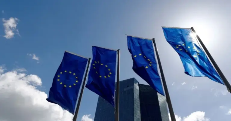 Друкований примірник регламенту програми AGILE на тлі прапорів Євросоюзу та України